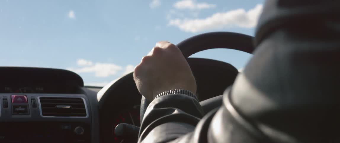 Close up of a person hand as they drive a car