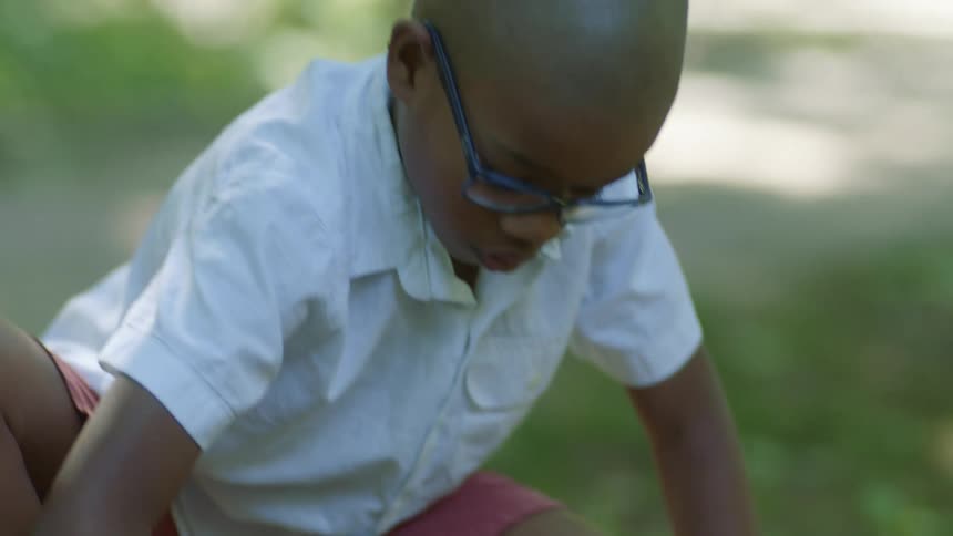 A child is drawing with chalk on the ground