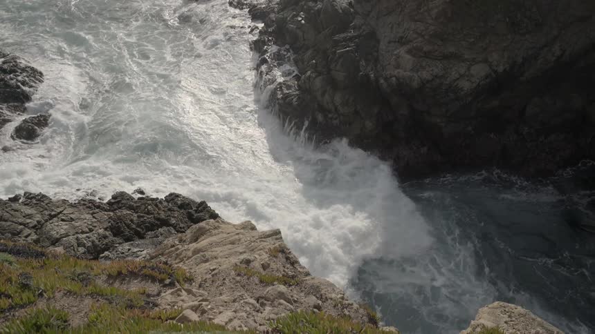 Waves crash against rocks near the shore