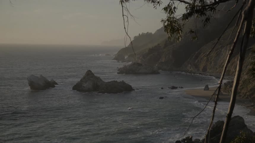 The tide meets the shore of a beach and cliff coastline