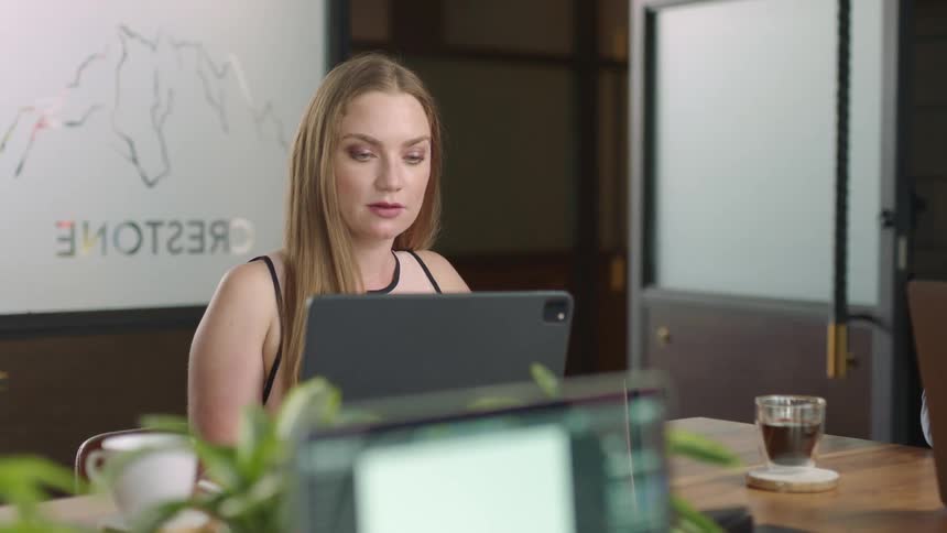 A woman looking at tablet in a meeting