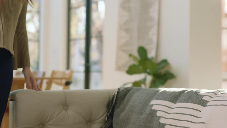 A woman sitting down on a couch with laptop