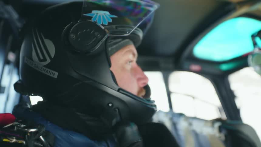 A man is putting a helmet on in a helicopter