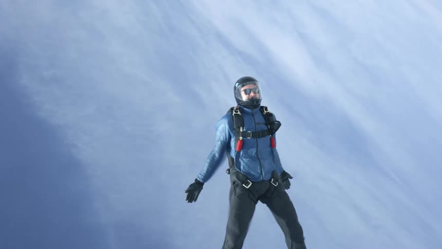 A skydiver with an undeployed chute soars through the air