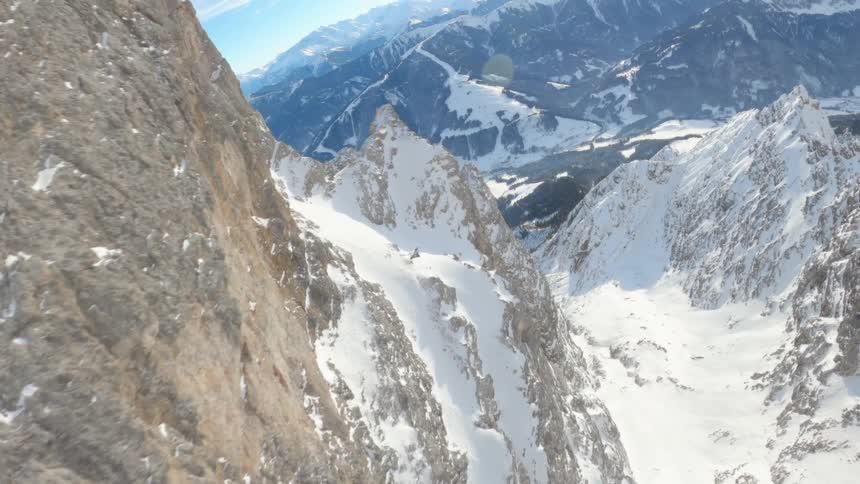 Snow covers the ground and sides of a mountains in a vast mountain range