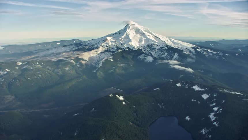 Approaching Mount Hood outside of Portland Oregon in winter with snow blowing off the summit of the mountain in the middle of winter