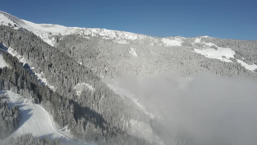Clouds floating above snowy mountains on a winter day