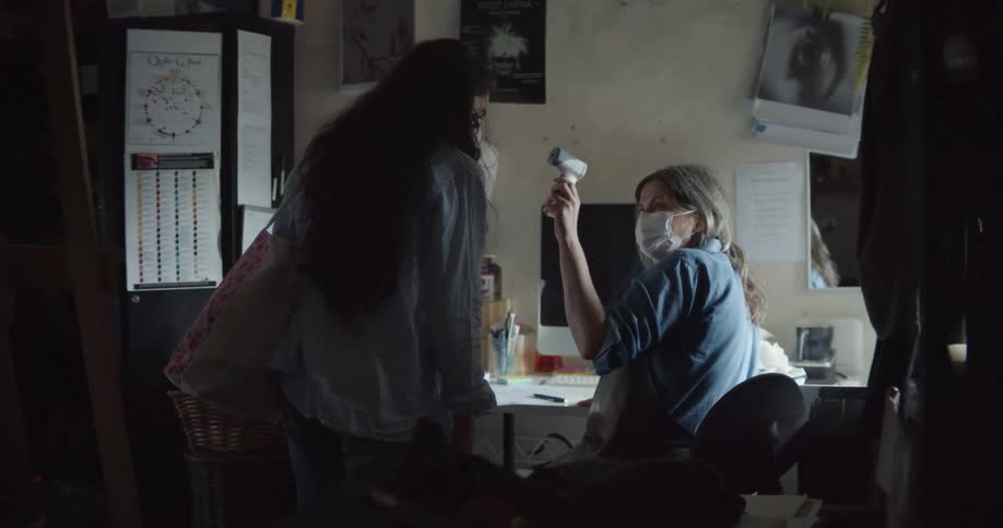 A woman checking an employees temperature in an office