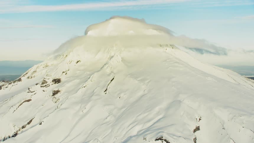 Epic winter hyper lapse rotating around the peak of Mount Hood as seen from the air of an airplane in a stunning perspective of the mountains