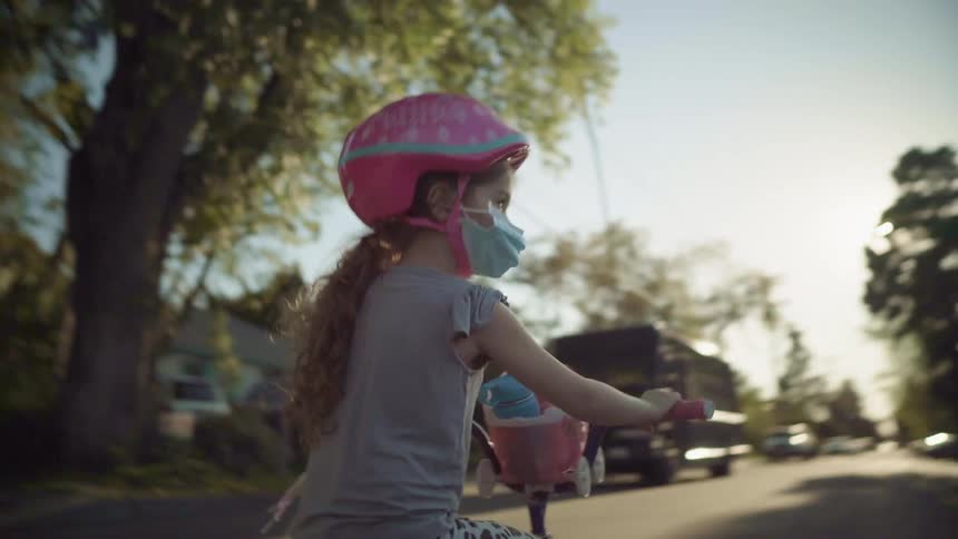 A girl rides her bike on the street