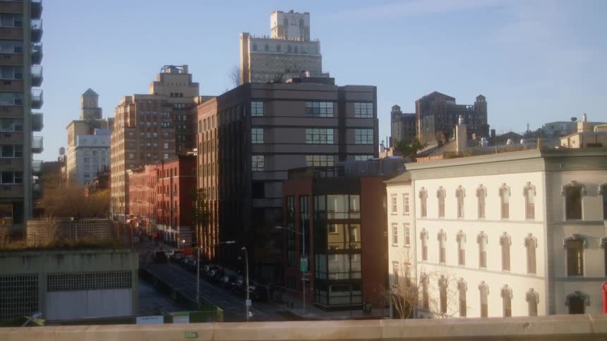 Several tall buildings fill a crowded downtown area as cars can be seen passing by