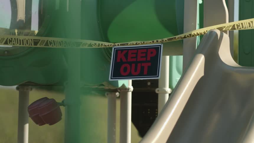 Caution tape and a keep out sign on a playground structure