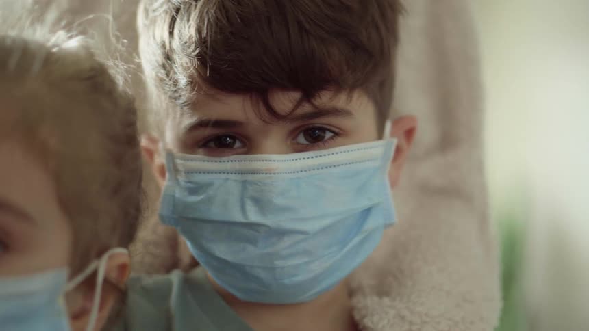 Two children are wearing blue face masks