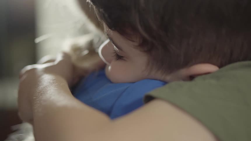 A boy and a girl in a room hugging