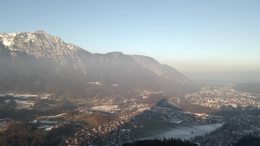 A town sits in the fog by the mountains