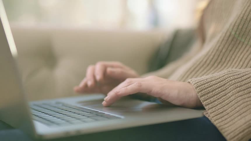 A woman browsing on laptop on a couch