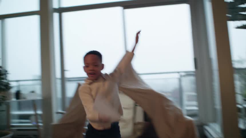 A child running around playing with a paper airplane