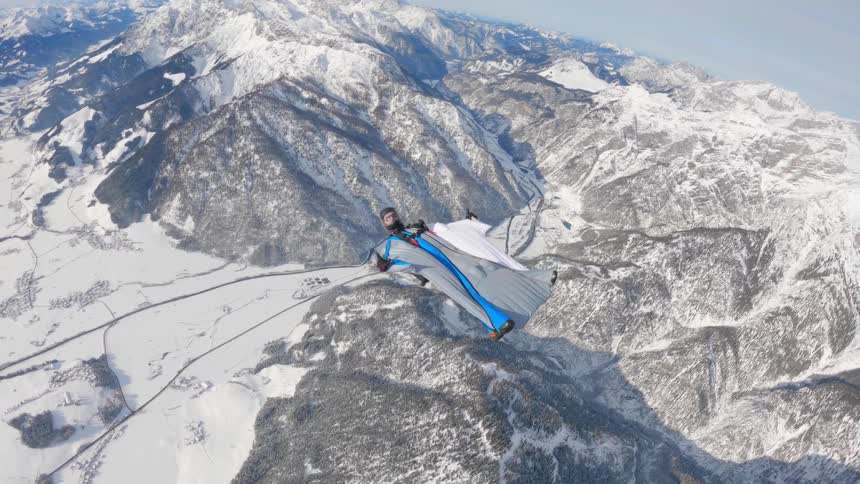 A person is wind riding high above the mountains