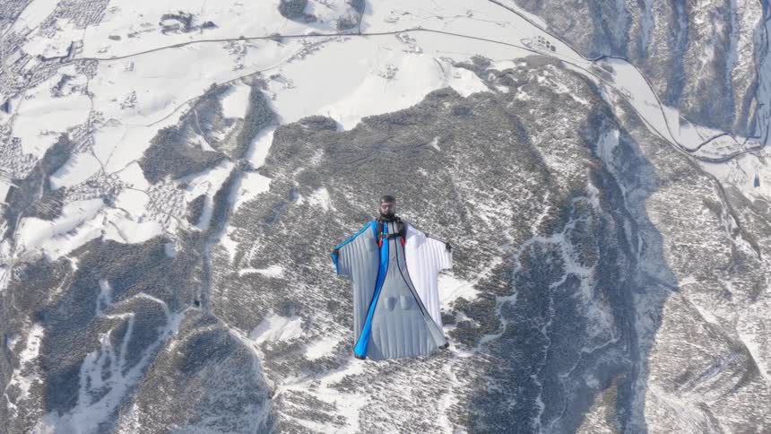A person is wind riding over the snow covered mountains
