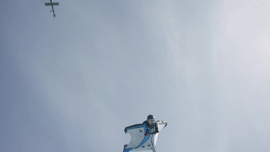 Wingsuit flyer jumping out o helicopter and floating in the air