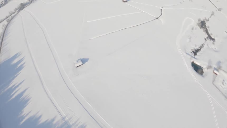 An aerial view of a rural snowy field on a winter day