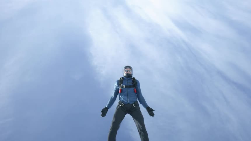 A man in sports safety gear sky diving in the sky during the day