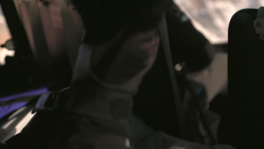 Two people are sitting in a moving helicopter