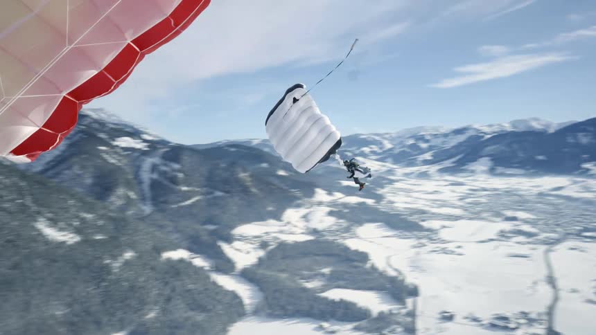 A person with their parachute open sky dives above the snowy landscape
