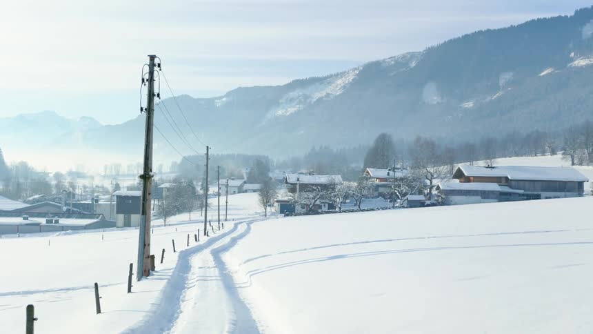 Snow on mountains near a small city with houses