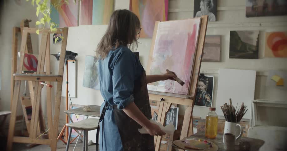 A female artist painting on a canvas in an art studio