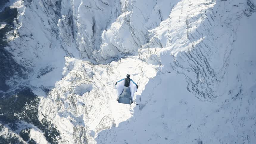 A person base jumping out of a helicopter in a wing suit