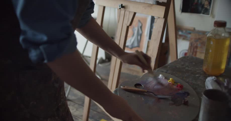 A woman is painting in a room during the day