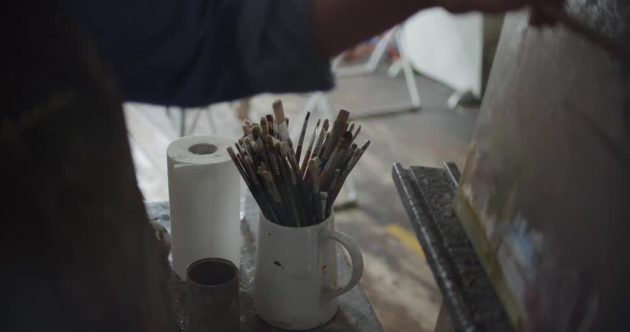 A female artist painting on a canvas in an art studio