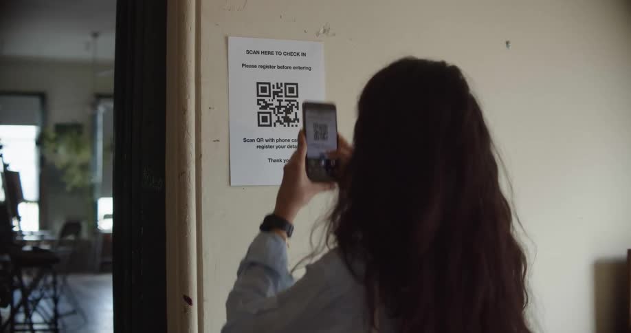 A woman scanning a qr code on a wall with her phone