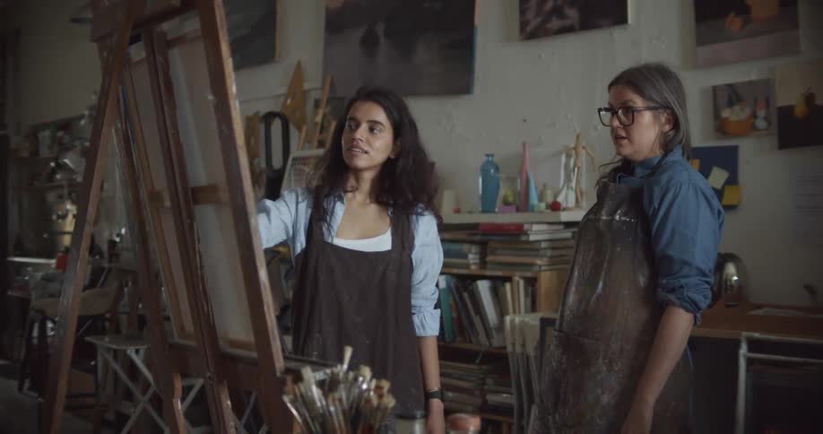 A woman teaching another one how to paint