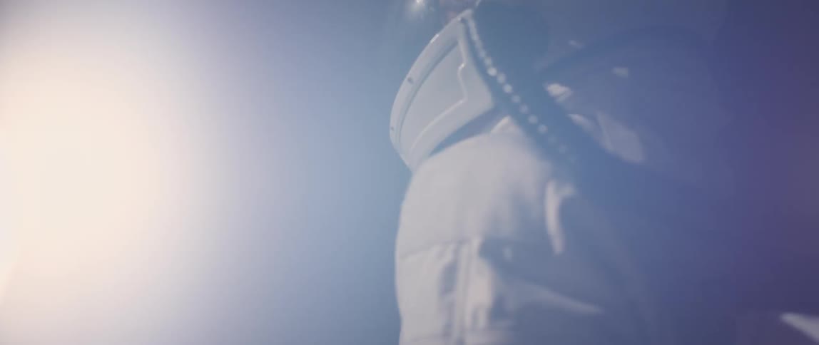 A person wearing astronaut gear turns around