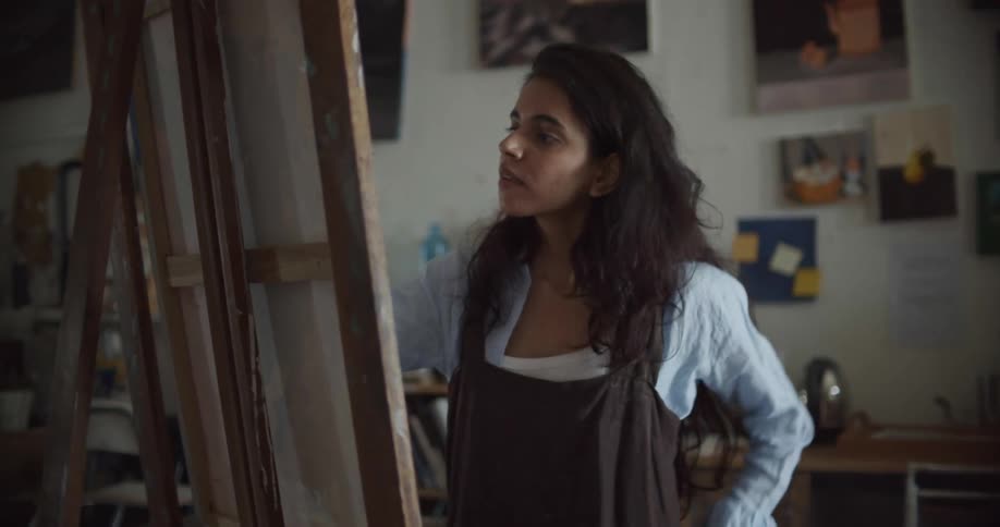 A woman is painting on a canvas indoors