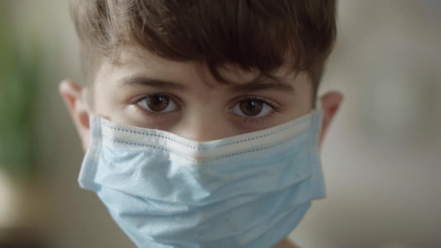 Boy wearing face mask stares