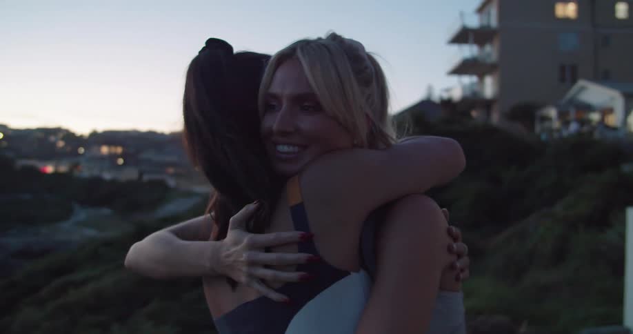 Two women hugging each other and smiling