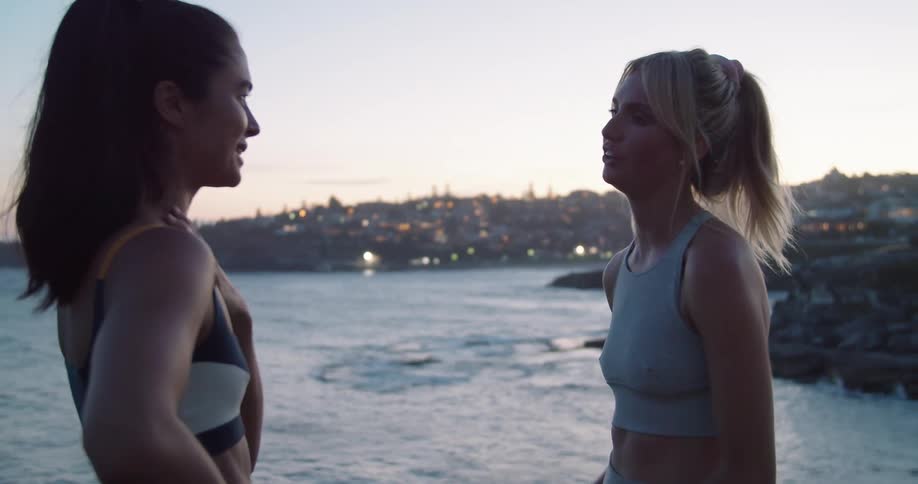 Two women are talking to each other by the coast