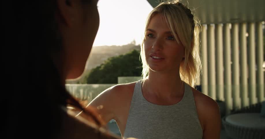 Pretty blonde woman listening to a friend outside on a balcony