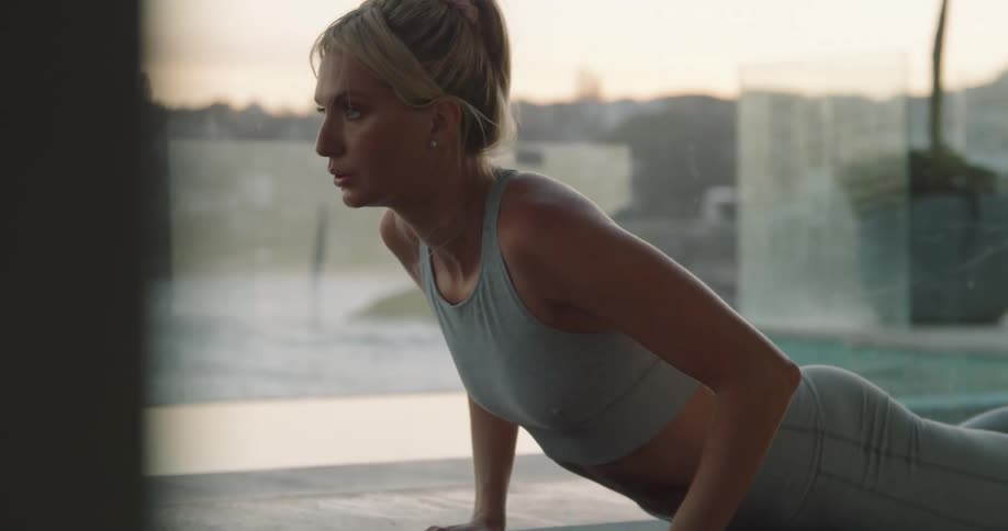 A woman in a room on the floor on a mat stretching