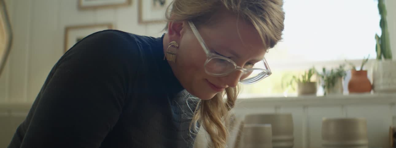 A woman writing something down sitting in a room