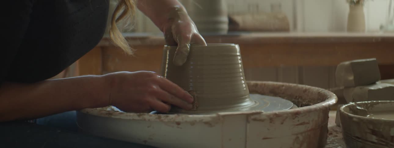 A woman working with pottery on a wheel