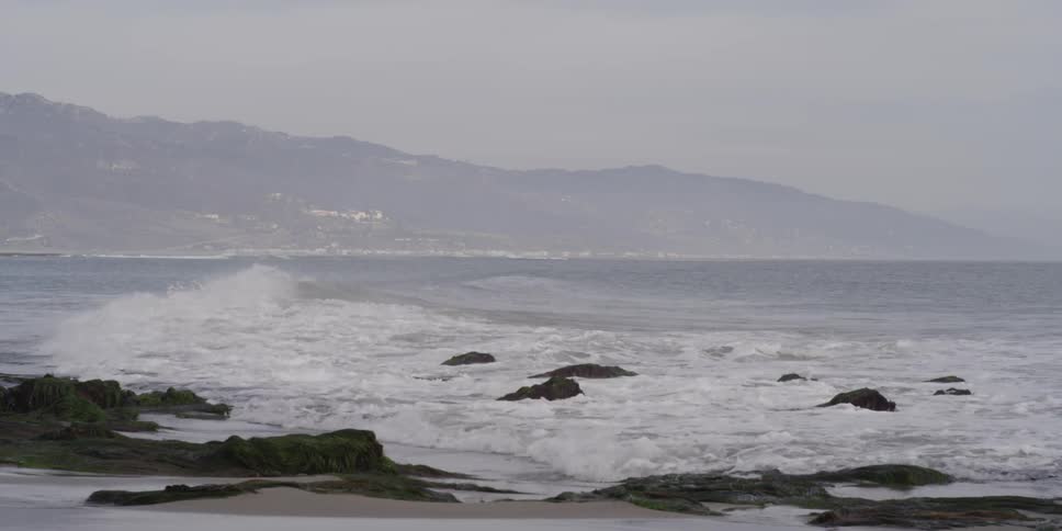 Waves crashing over rocks along a rocky shore