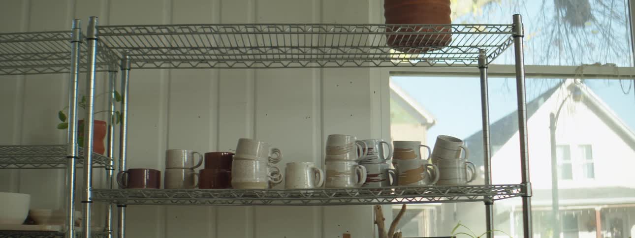 Cups are stacked in a kitchen next to a window