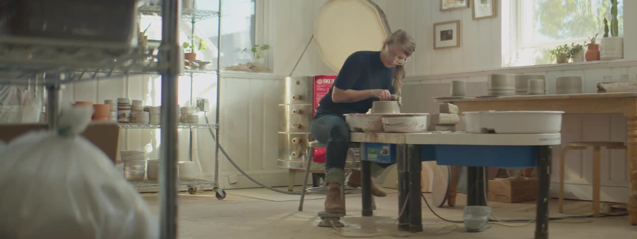 A woman working on pottery in a studio