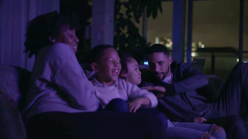 A family sitting down to watch something on tv