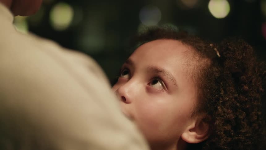 A person kissing a young girls forehead
