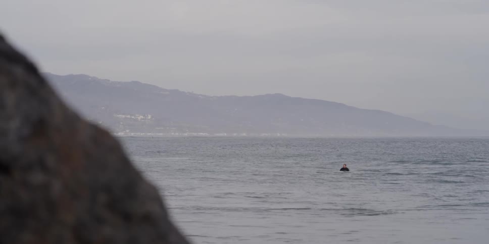 A person is floating in the water off shore